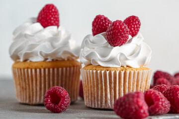 Tasty raspberry cupcakes and fresh berries on table