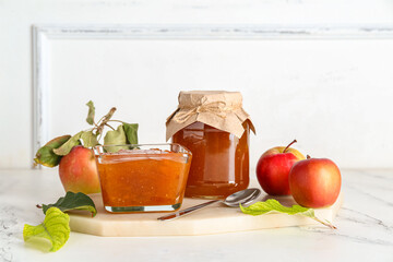 Board with sweet apple jam and fresh fruits on light table