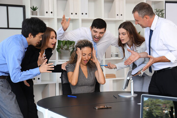 Mature businesswoman suffering from noisy colleagues in office