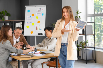 Fototapeta premium Young businesswoman with tablet computer in office