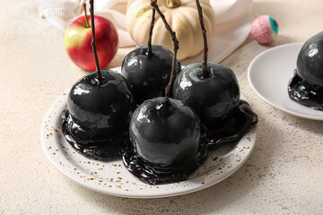 Plate of tasty caramel apples for Halloween on white background