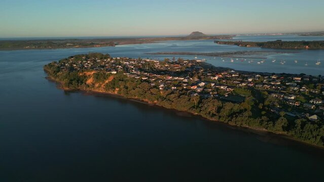 Sunset aerial view of coastal neighborhood in Akaroa, New Zealand, overlooking Mount Manganui