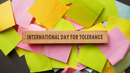 The words International Day for Tolerance are engraved on a wooden block with the date 16. Happy...