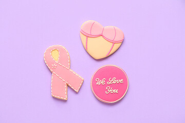 Pink cookies with ribbon, bra and words WE LOVE YOU on lilac background. Breast cancer awareness concept