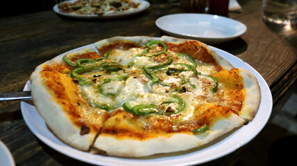 Pizza with one topping,close view oa pizza on a white plate with wooden background
