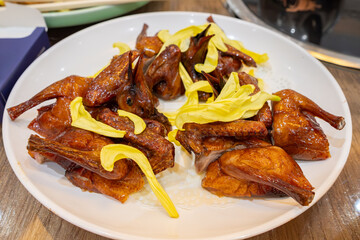 dish of roasted pigeons with chrysanthemum petals