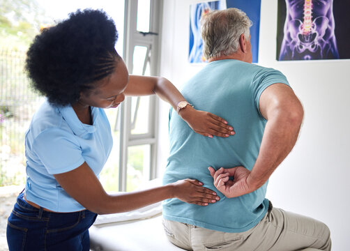 Physiotherapy, chiropractor and senior man with back pain or physiotherapist consulting a patient for muscle injury. Arthritis, physical and medical professional help elderly person with massage