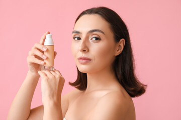 Young woman with makeup foundation on pink background, closeup
