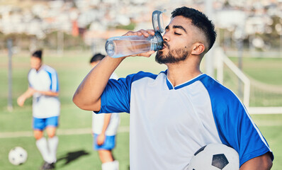 Football, athlete and man drinking water outdoor on a sports field for fitness competition. Tired...