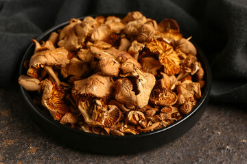 Plate with tasty dried mushrooms on dark background