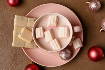 Cup of hot chocolate with marshmallows and Christmas balls on brown background
