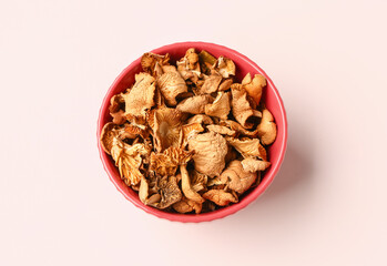 Red bowl with tasty dried mushrooms on white background