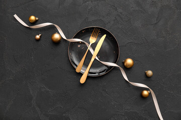 Beautiful table setting with Christmas balls and ribbon on black background