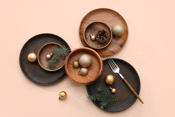 Beautiful table setting with Christmas balls, cone and fir branches on beige background