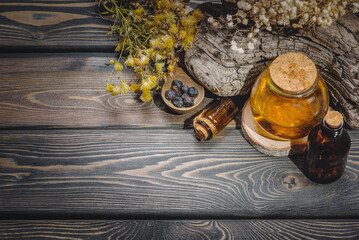 Herbal medicine concept background. Dry natural ingredients and remedy bottle on the wooden table background with copy space. Top view. Witchcraft.