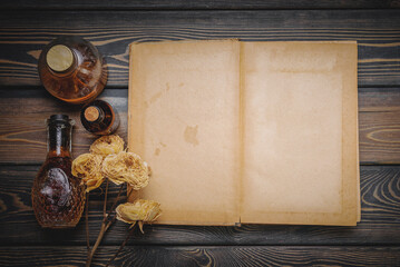 Recipe book. Magic book. Herbal medicine concept background. Dry natural ingredients and remedy bottle on the wooden table background with copy space. Top view. Witchcraft.