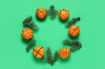 Frame made of pomander balls with Christmas tree branches on green background