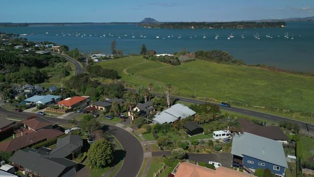 Aerial drone view of neighborhood with luxurious bayfront homes in Omokoroa, New Zealand, overlooking the bay