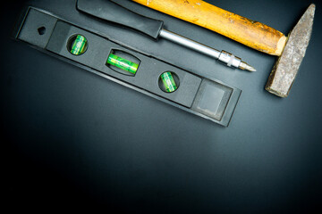 screwdriver hammer and spirit level isolated on black background