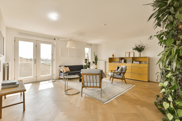 a living room with wood flooring and large sliding glass doors that open onto the balcony overlooking out to the garden