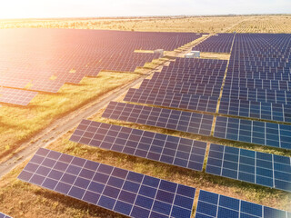 Aerial top view of a solar panels power plant. Photovoltaic solar panels at sunrise and sunset in...