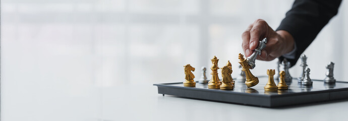 Businessman's hands move chess figures and checkmate opponent during match. Strategy, management, leadership, analysis of development for organizational success. copy space, banner, panorama - obrazy, fototapety, plakaty
