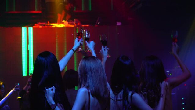group of diversity happy woman sexy young people enjoy dancing holding glasses of champagne for cocktails drinking alcoholic beverages have fun nightlife in night club