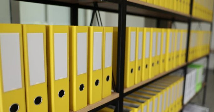 Yellow identical office folders on bookshelf in office