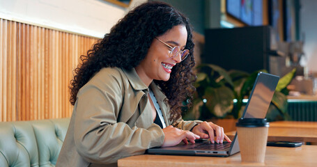Happy woman in coffee shop, typing on computer and remote work, reading email or writing blog, article or search on internet. Laptop, freelancer and copywriting in cafe, smile at restaurant or table - obrazy, fototapety, plakaty