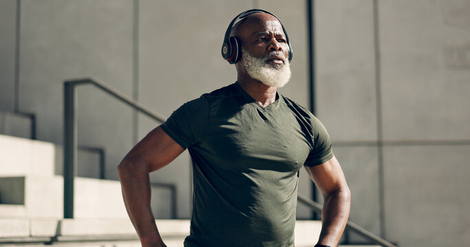 Mature, black man and exercise with headphones for fitness, workout and runner rest for breathing outdoor on stairs. Thinking, training and athlete listening to music, podcast or radio for motivation