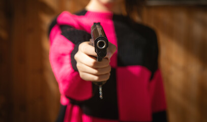 Caucasian young woman holding a pistol.