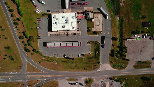 Semi trucks and trailers exiting truck stop from Jasper Florida. Top down aerial