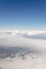 Beautiful view from the airplane window from above to the clouds, mountains, roads, rivers. Picturesque landscape from a helicopter window on a sunny day.