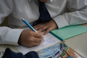 Almaty, Kazakhstan - 09.06.2023 : Schoolchildren write a dictation about autumn in class.