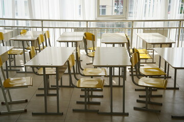 Almaty, Kazakhstan - 09.06.2023 : School desks stand in a row in an empty classroom.
