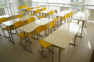 Almaty, Kazakhstan - 09.06.2023 : School desks stand in a row in an empty classroom.