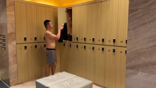 Asian Millennial Man Wearing Shirt in Luxurious Changing Room in a High End Gym Facility
