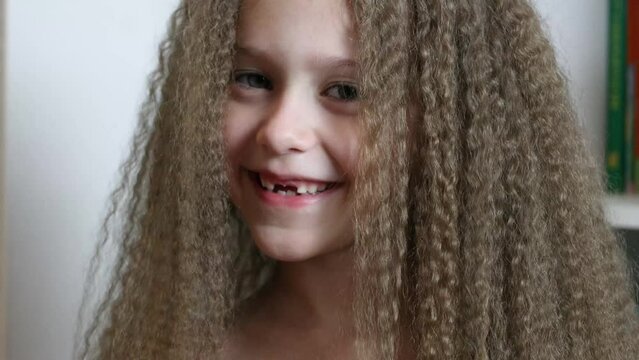 Cute little girl smiles and shows her fallen front milk teeth. Teeth growth. Close-up. Portrait of a 6-year-old rebec