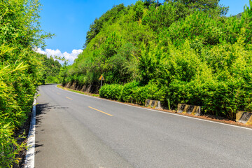 Highway and green mountain landscape under blue sky