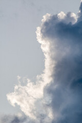 Obraz premium Big stormy clouds in a bright sunny day before sunset