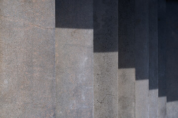 Top view outdoors cement down stairs and shadow, The light shines on the stairs causing shadows. Looking down from the top of stairs.
