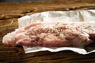 Raw pork belly and dried spices on a cutting board	