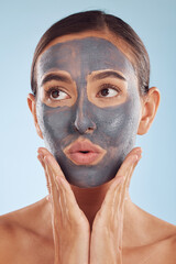 Face mask, skincare and beauty of woman with cosmetic facial treatment isolated in a blue studio background. Skin, charcoal and young female person with clean, hydration and dermatology cream