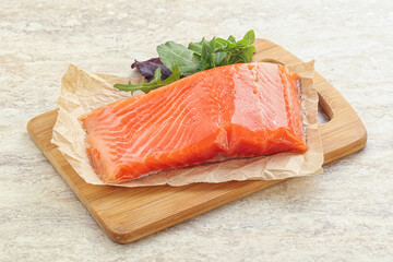 Raw salmon fillet over board