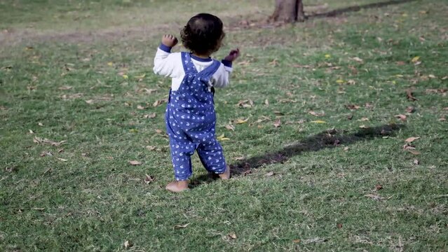cute toddler trying to walk at park green grass from different angle
