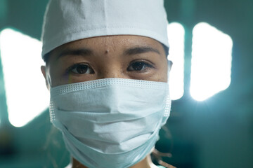 Portrait of asian female surgeon wearing face mask in operating theatre at hospital