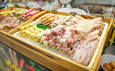 Obraz premium Various Meatballs Skewers Display, Meat skewers, Fresh ingredients Skewers, Meatballs and sausage Thai street food for Shabu, grilled, steamed in the market.