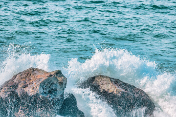 Water splashes close up. Crystal clear sea water beats against the rocks. Sea waves break on the...