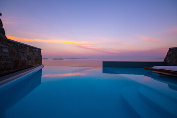 Infinity swimming pool in the villa at sunset time, Mykonos, Greece - obrazy, fototapety, plakaty