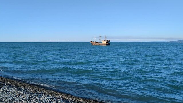 Wooden ship sailing on horizon. Sunny day. Black sea.